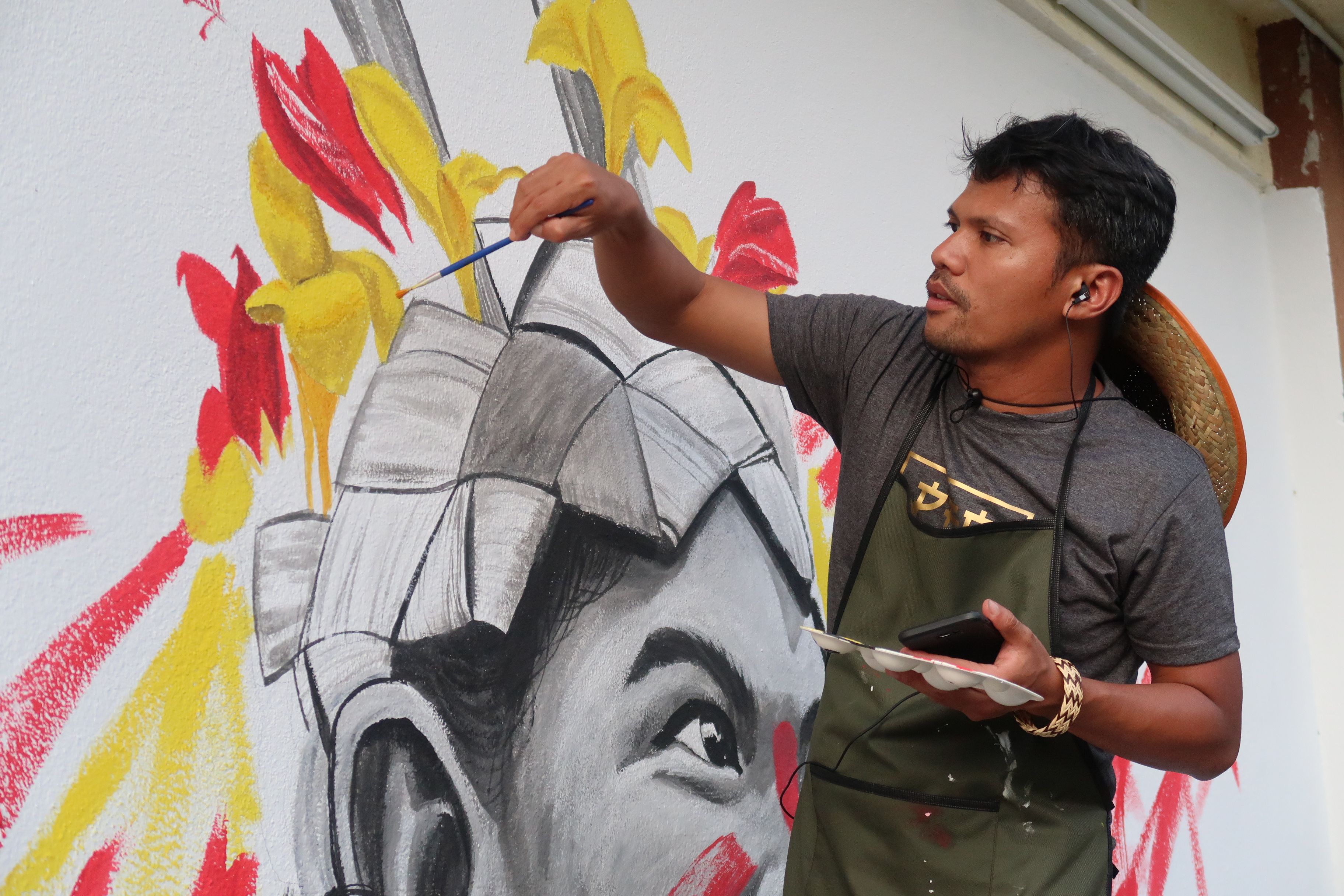 Shaq Koyok working on a mural at an Indigenous school in Perak, 2019.